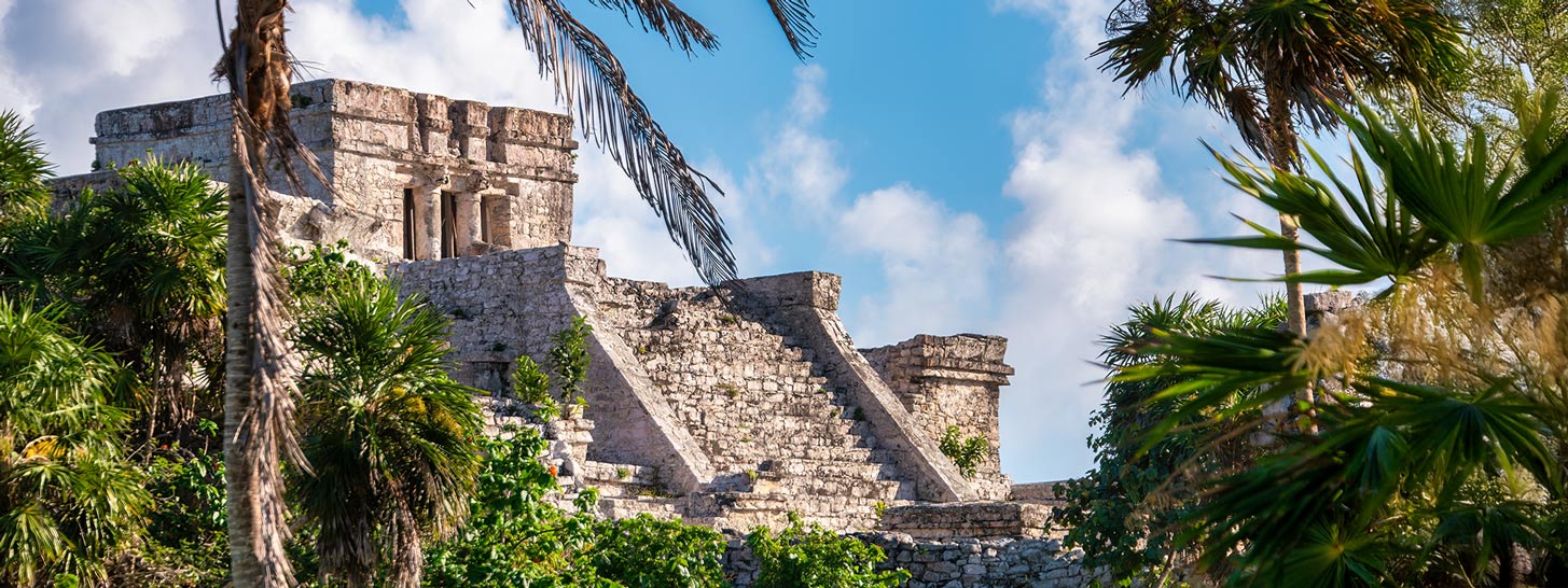 El Castillo, la estructura icónica de los mayas que se alza sobre el mar Caribe en Tulum, un destino obligatorio para los amantes de la historia. Viaja de manera sostenible con Flex Eco Taxi.