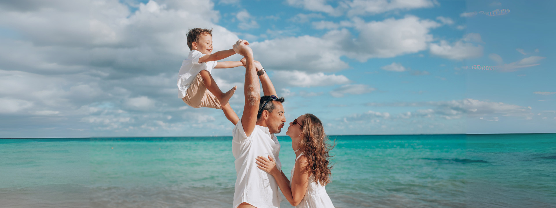 Familia disfrutando junta en la playa de Cozumel, rodeada de arena blanca y mar turquesa. Momentos inolvidables con Flex en el paraíso.