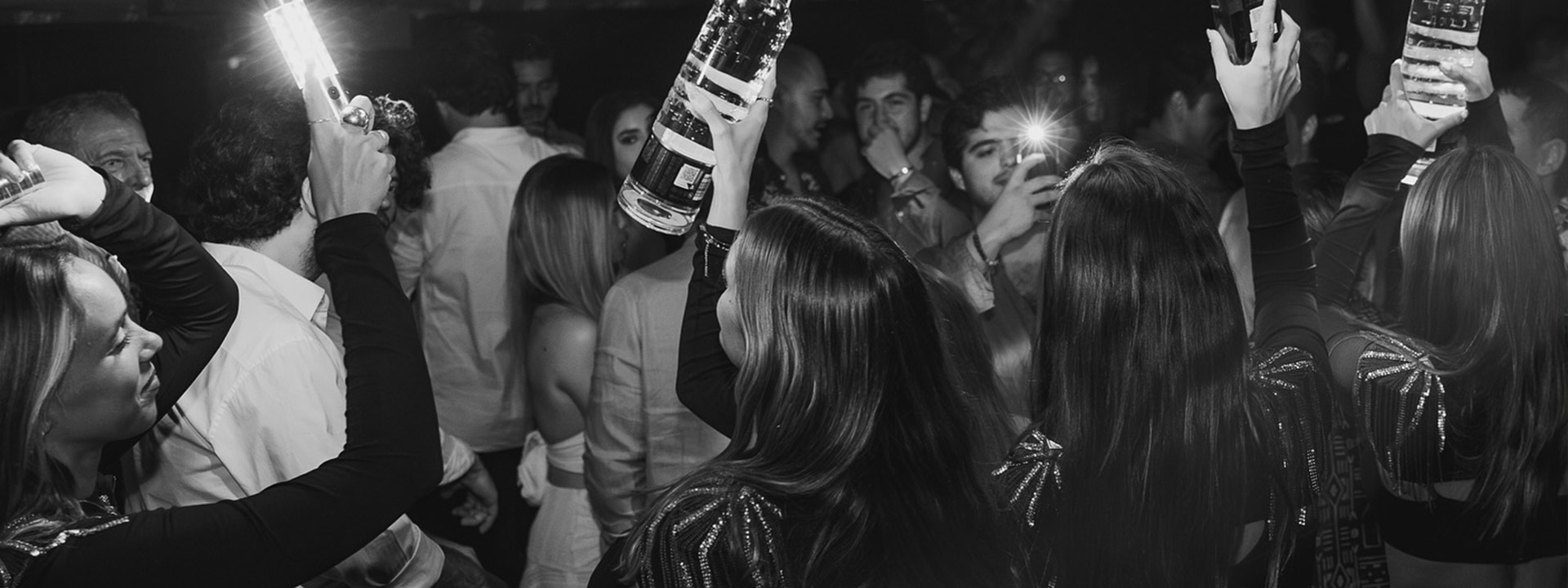 People having a great time at H Roof Cancún, with stunning views and lively ambiance as guests enjoy drinks, music, and dancing under the stars.