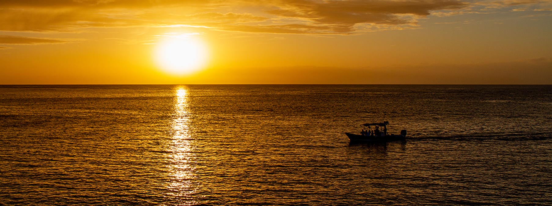 A stunning Cozumel sunset over the Caribbean Sea, capturing the vibrant colors of the sky and water."