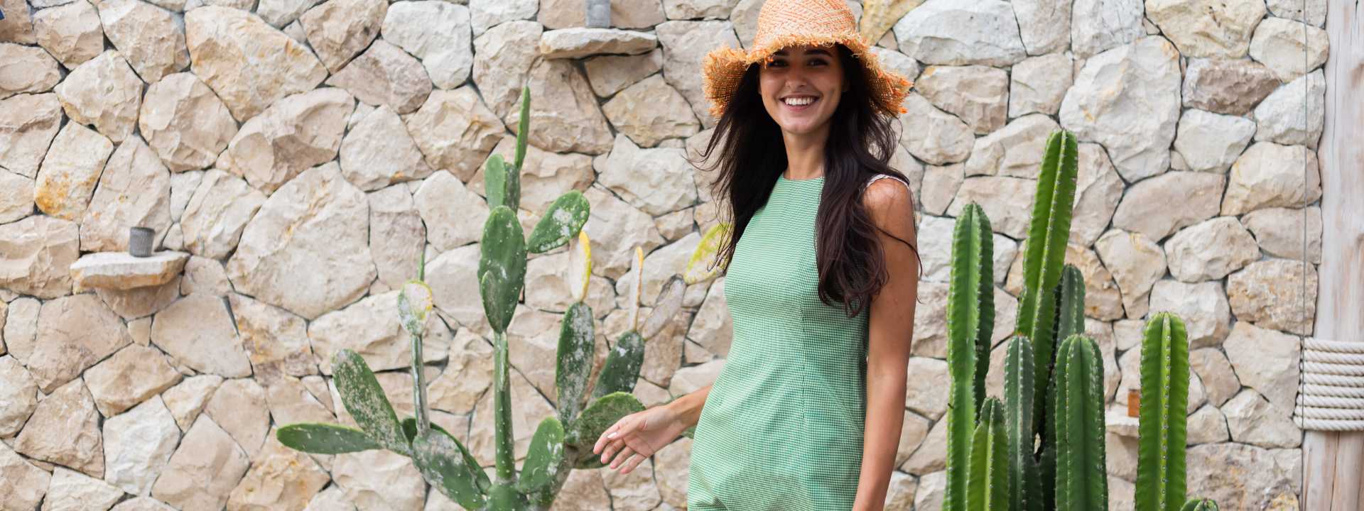 Smiling woman posing outdoors while enjoying her trip; her face reflects happiness and a sense of freedom.